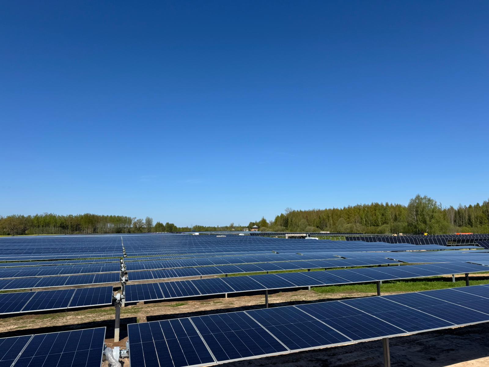 Lielvarde päikesepark Lätis, sinise taeva all maapealsed päikesepaneelid metsa ääres
