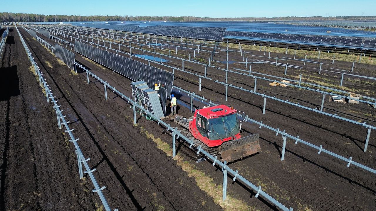 Päikesepaneelide paigaldus Risti Solar Tracker Pargis, töömehed ja paigaldusmasin paneeliridade vahel