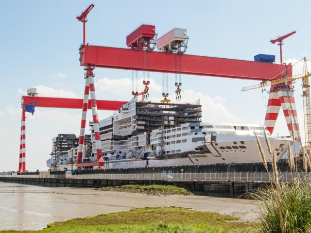 Saint-Nazaire'i laevatehas Prantsusmaal — punane kraan ja kruiisilaeva kere ehituses